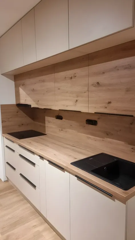 Bílé skříňky s&nbsp;deskou a&nbsp;obkladem v&nbsp;dekoru starého dubu