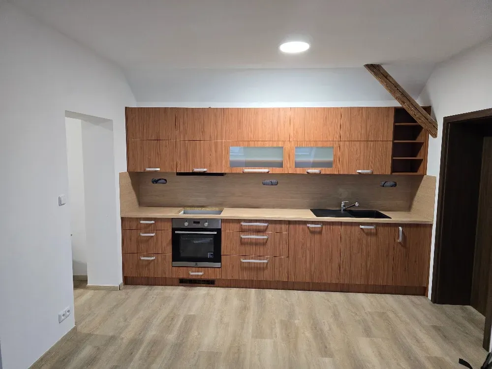 Dlouhá linka v&nbsp;ořechovém dekoru s&nbsp;šedou deskou a&nbsp;digestoří