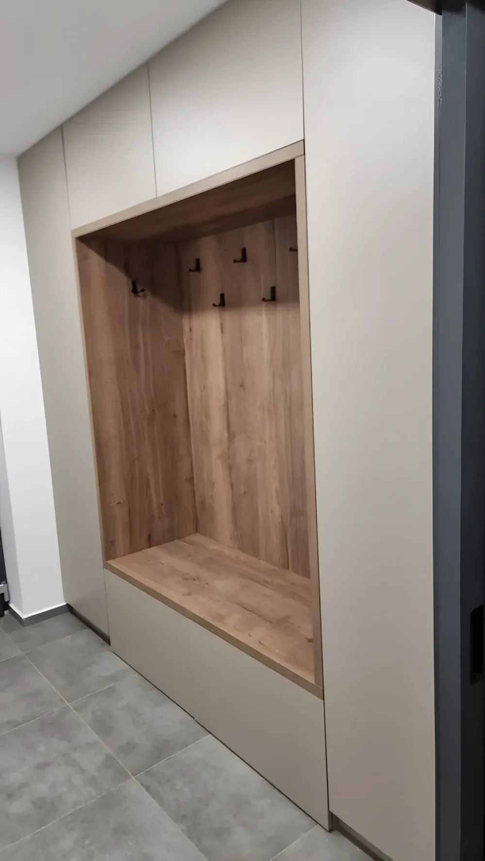 Světlá vestavěná nika s&nbsp;dubovým obkladem, věšáky a&nbsp;lavicí