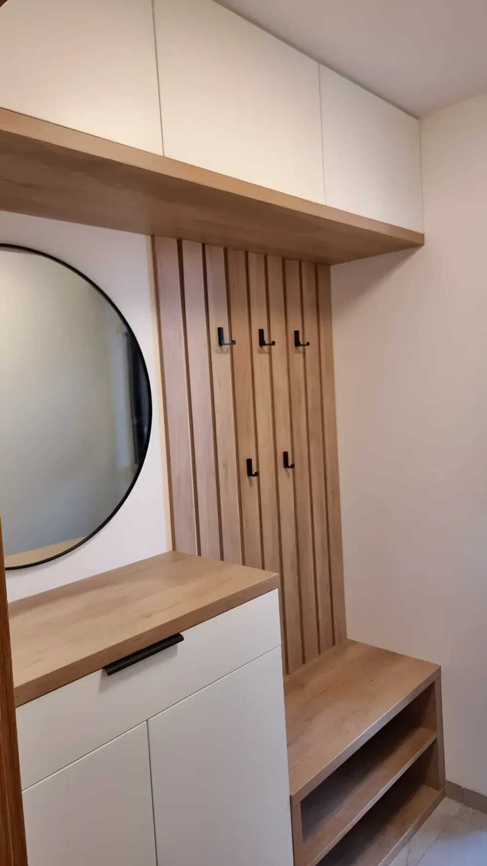Předsíň s&nbsp;lamelovým obkladem, kulatým zrcadlem a&nbsp;dubovou lavicí