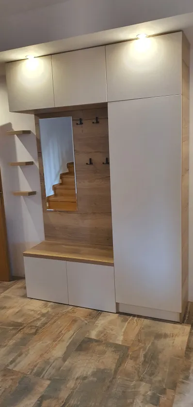 Předsíňová stěna ve světlém dekoru s&nbsp;dubovou lavicí, zrcadlem a&nbsp;bodovými světly