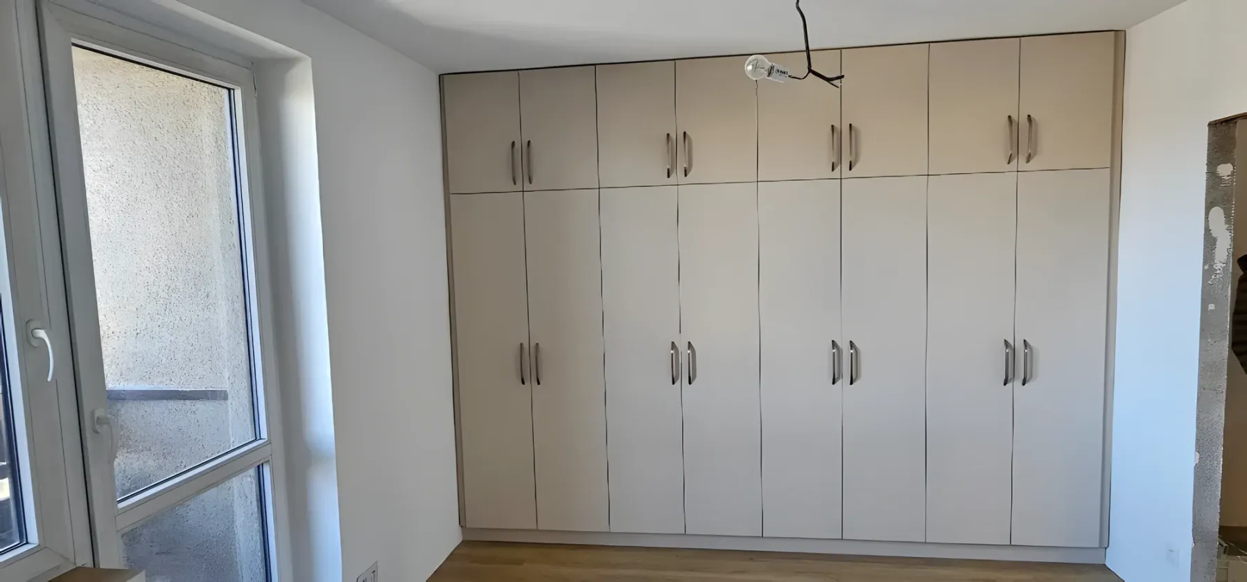 Světlá šatní stěna s&nbsp;dvaceti dvířky přes celou místnost
