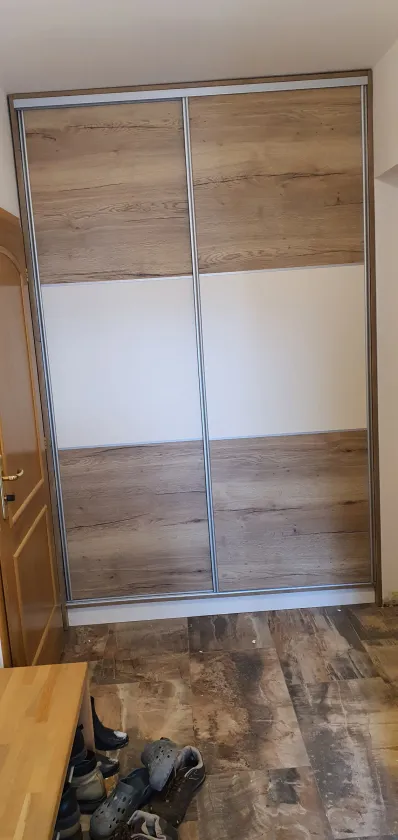 Posuvné dveře v&nbsp;kombinaci dubu a&nbsp;bílé na tmavé podlaze