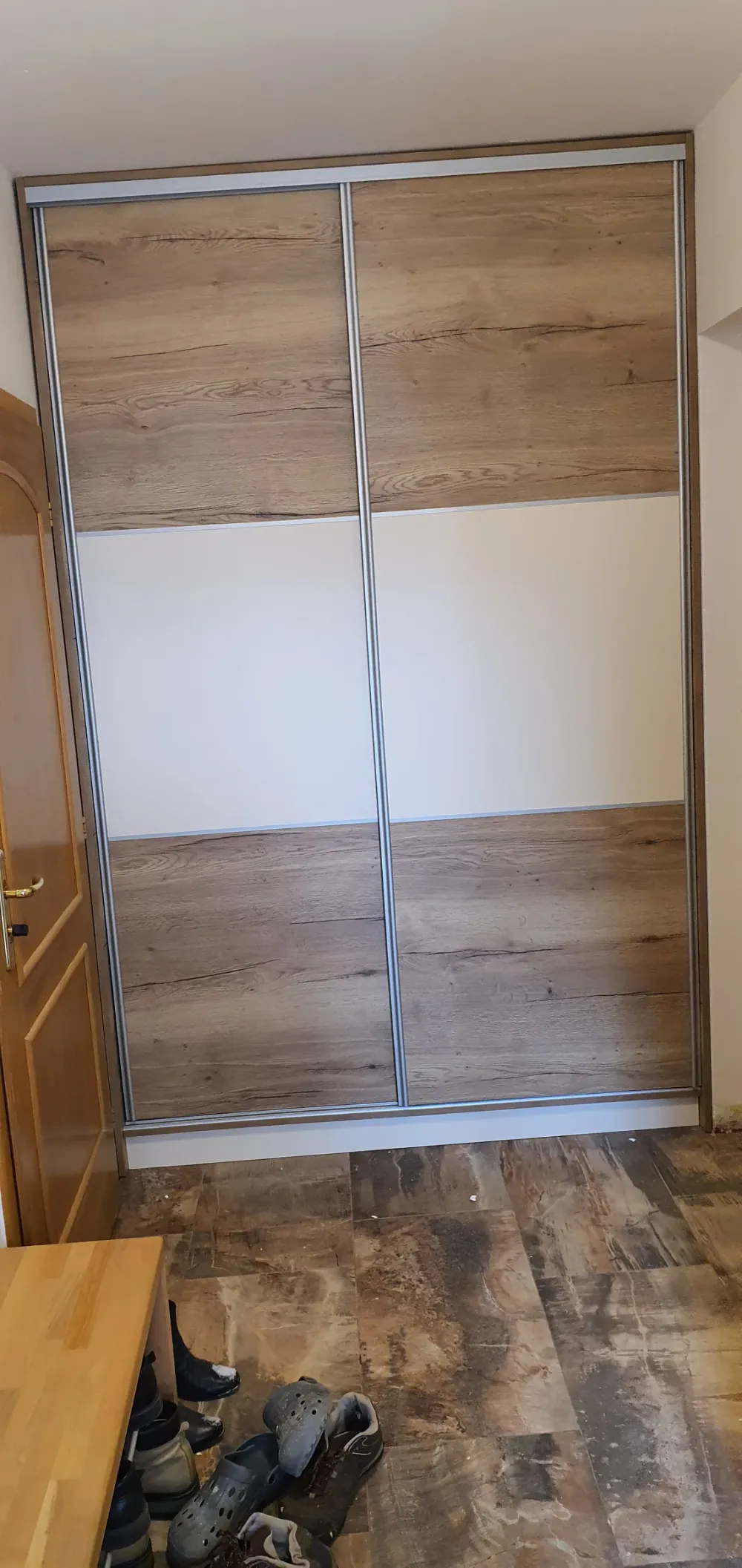 Posuvné dveře v&nbsp;kombinaci dubu a&nbsp;bílé na tmavé podlaze