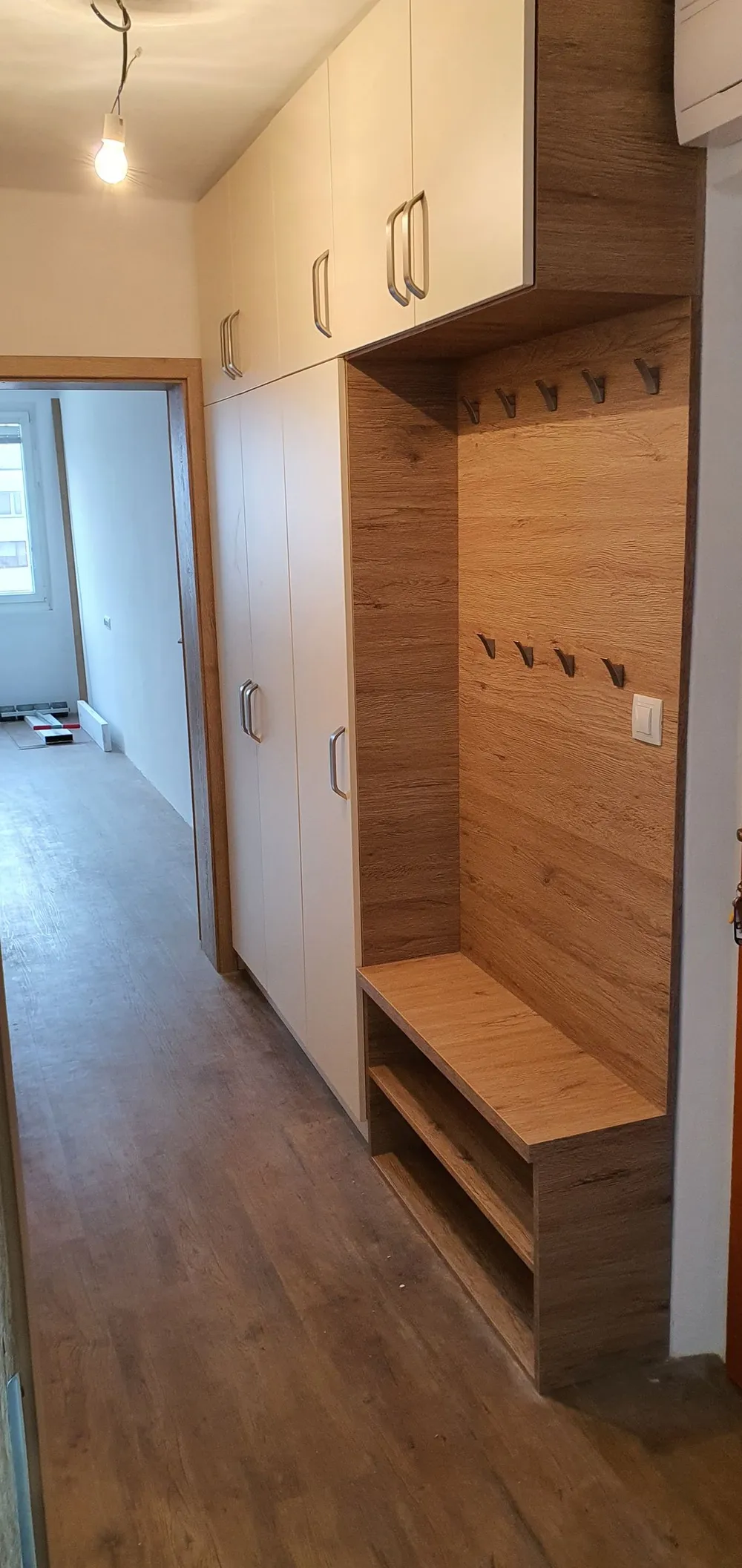 Předsíňová stěna s&nbsp;dubovým obkladem, věšáky a&nbsp;lavicí pod skříní
