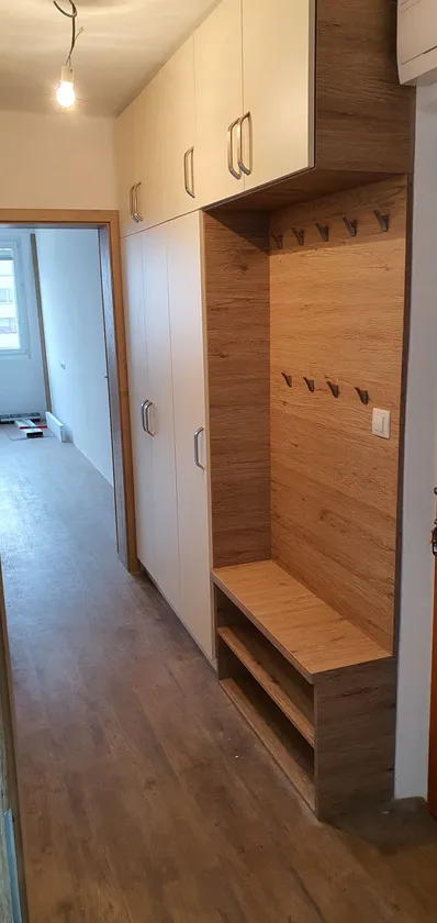 Předsíňová stěna s&nbsp;dubovým obkladem, věšáky a&nbsp;lavicí pod skříní